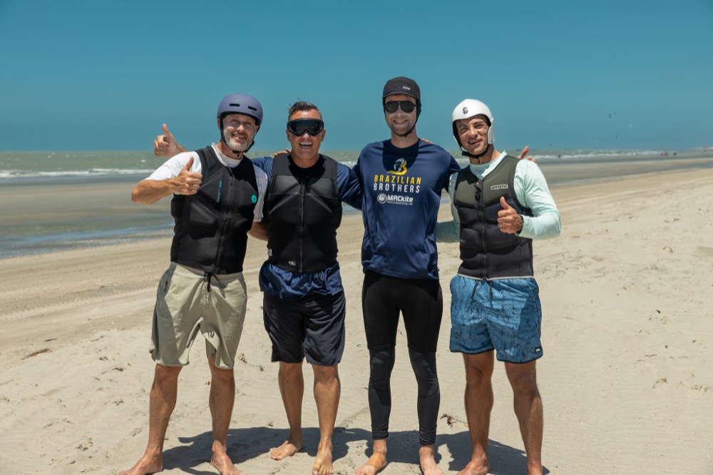 Four riders from the experience giving a thumbs-up on the beach