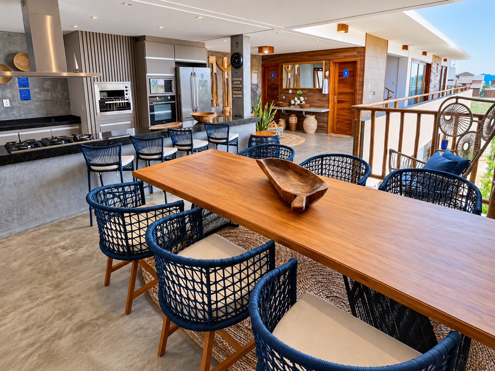 Open-plan kitchen and long wooden dining table opening onto the deck