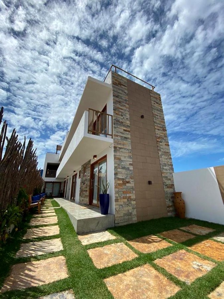 The Brazilian Brothers house in Preá: a modern two-storey home with a stone facade and a garden path