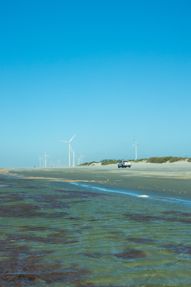 A wind turbine and a 4x4 on the beach at Barrinhas